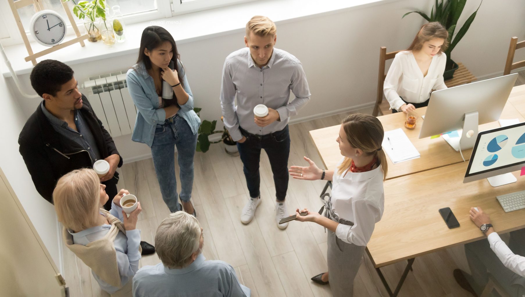 Team leaders meet multiracial interns in office explaining new job, company executives talking to diverse workers listening instructions at break, discussion and computer work in coworking, top view