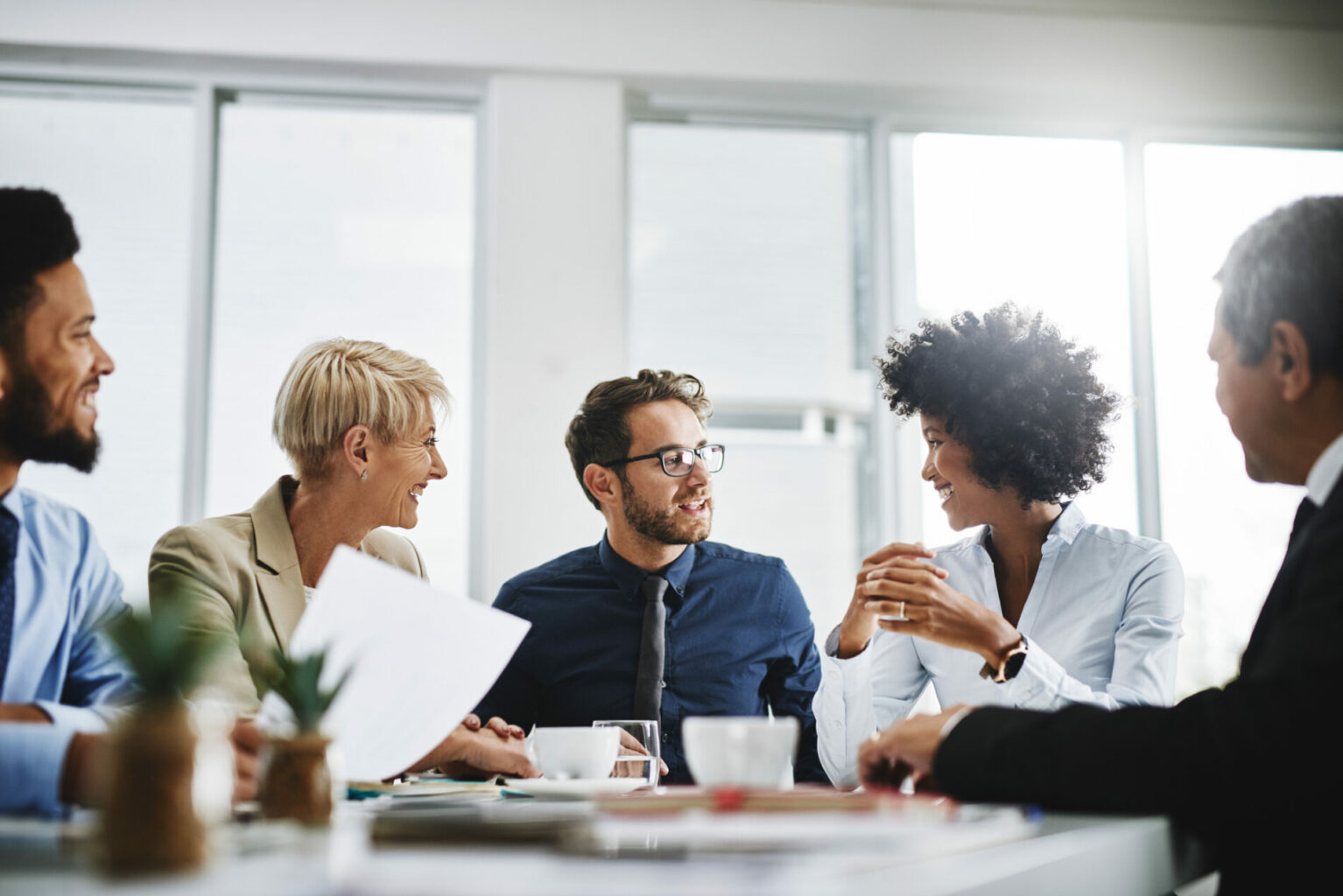 Cropped shot of a diverse group of businesspeople sitting together and having a meeting in the office